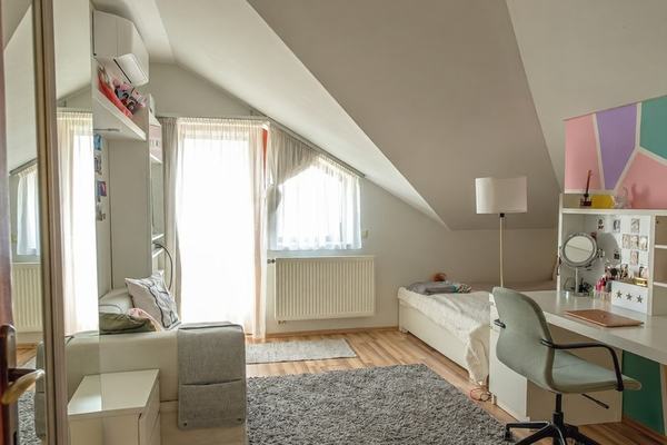 Világos tetőtéri gyerekszoba pasztell színekkel, íróasztallal és klímával